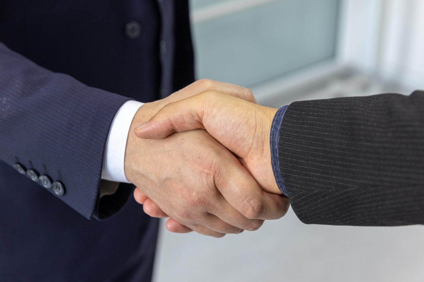 A business owner shaking hands with a supplier to agree on a new order