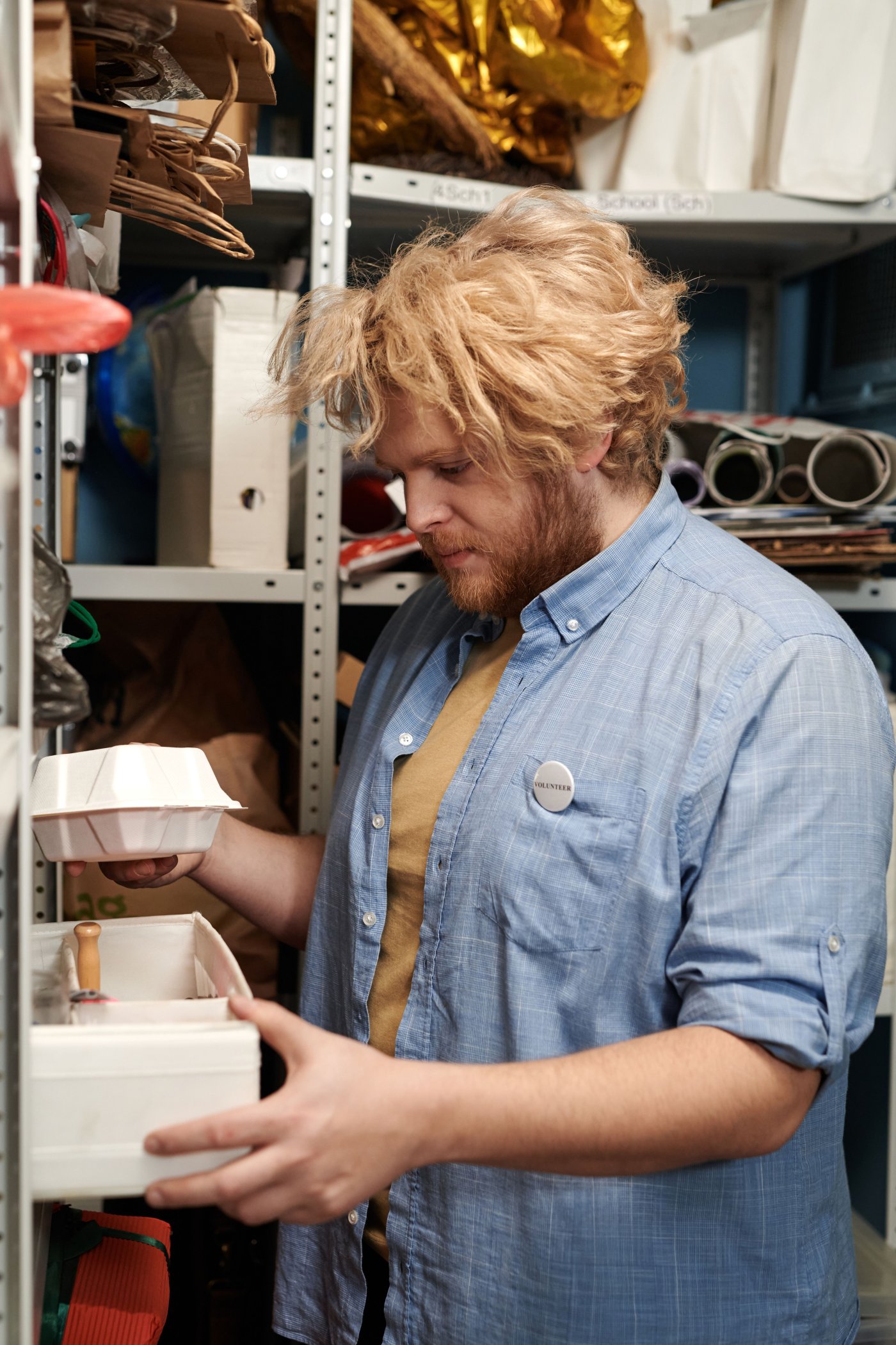 A small business owner checking stock boxes on shelves in the storeroom